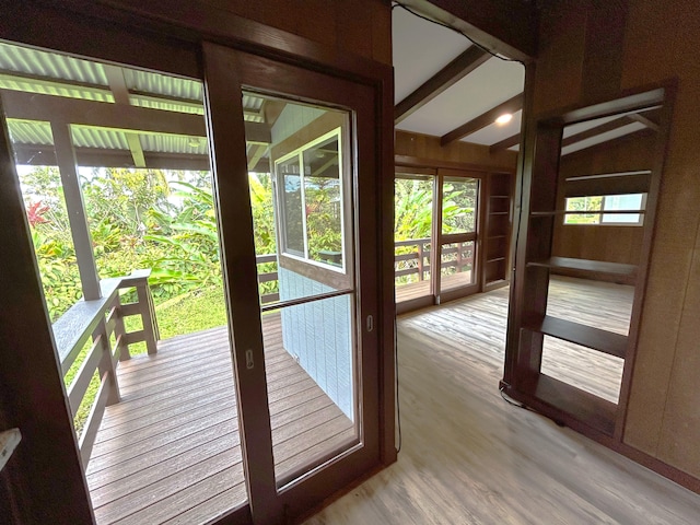 doorway with lofted ceiling with beams and light hardwood / wood-style floors