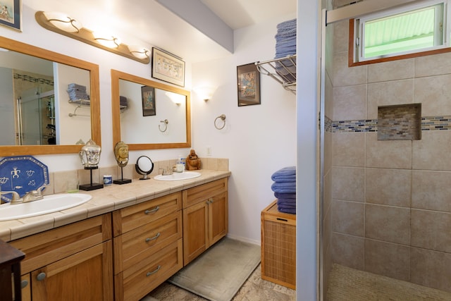 bathroom featuring a tile shower and vanity