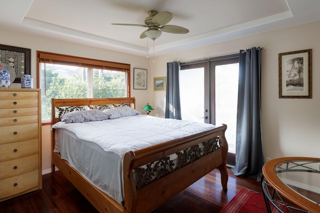 bedroom featuring a raised ceiling, ceiling fan, and dark hardwood / wood-style floors