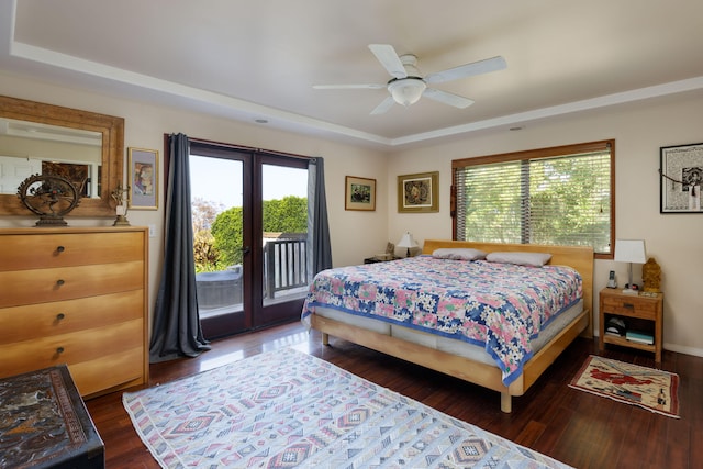 bedroom featuring ceiling fan, a raised ceiling, dark wood-type flooring, and access to outside