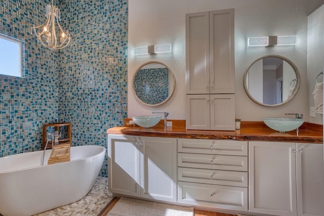 bathroom featuring a washtub, tile walls, and vanity