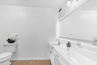 bathroom featuring tile patterned flooring, vanity, and toilet