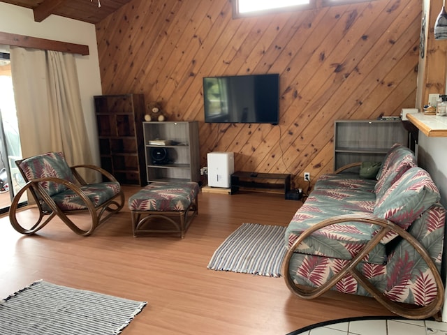 living room with beamed ceiling, wood-type flooring, wooden ceiling, and wooden walls