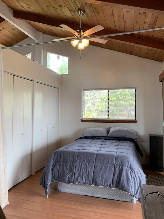 bedroom featuring light wood-type flooring, vaulted ceiling with beams, ceiling fan, and wood ceiling