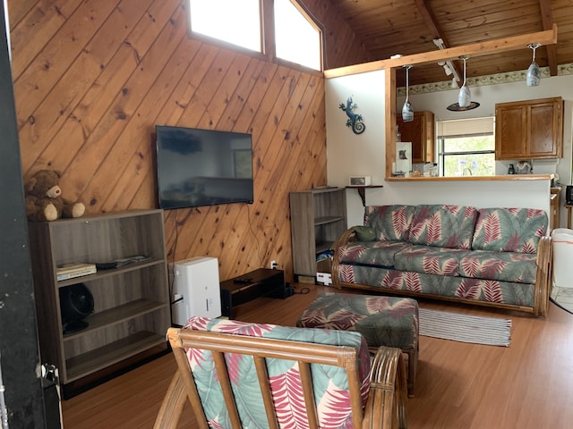 living room with beamed ceiling, light wood-type flooring, wood walls, and wood ceiling