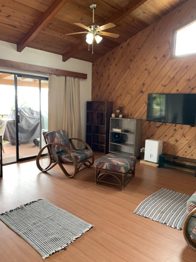 living room featuring ceiling fan, light hardwood / wood-style flooring, beamed ceiling, and wooden ceiling