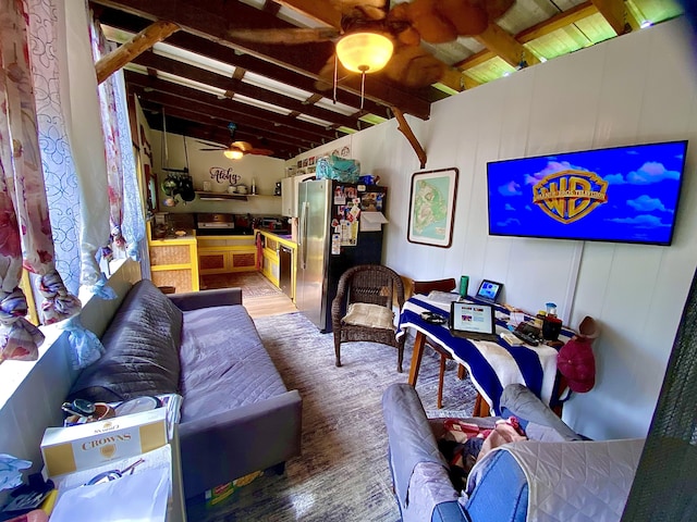 living room featuring beamed ceiling and ceiling fan