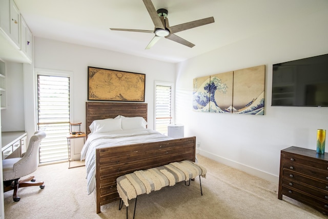 bedroom featuring multiple windows, ceiling fan, and light carpet