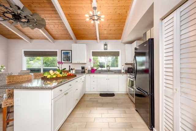 kitchen with black fridge, wooden ceiling, white cabinetry, plenty of natural light, and a breakfast bar area