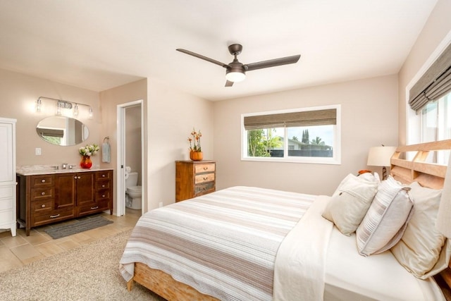 bedroom featuring ensuite bath and ceiling fan