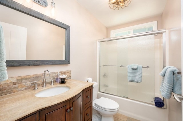 full bathroom featuring shower / bath combination with glass door, vanity, tasteful backsplash, and toilet