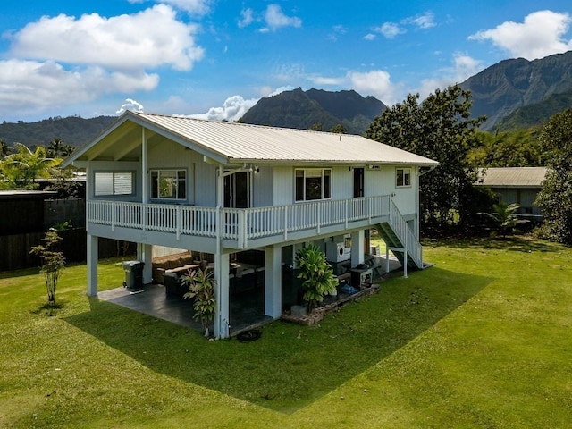 rear view of house featuring a yard and a deck with mountain view