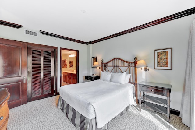 carpeted bedroom with crown molding and ensuite bathroom