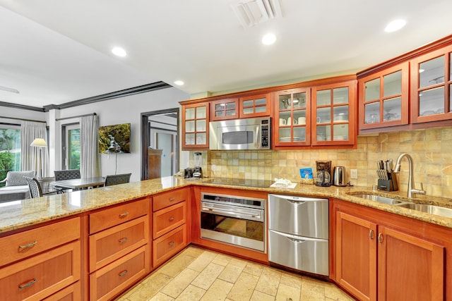 kitchen featuring light stone counters, sink, decorative backsplash, and appliances with stainless steel finishes