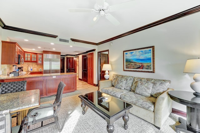 living room featuring sink, crown molding, and ceiling fan