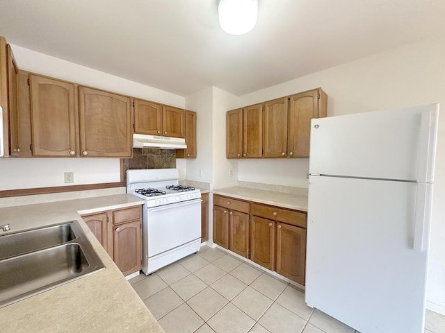 kitchen featuring light tile patterned flooring, white appliances, tasteful backsplash, and sink