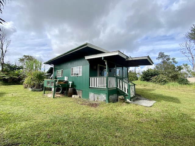 view of property exterior with covered porch and a yard