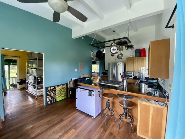 kitchen with ceiling fan, stainless steel fridge, beam ceiling, dark hardwood / wood-style flooring, and kitchen peninsula