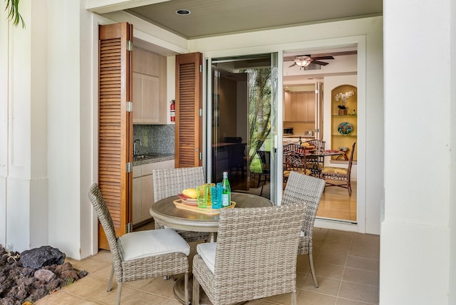 tiled dining space with ceiling fan and sink