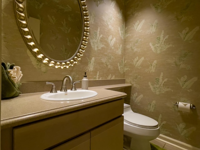 bathroom with toilet, vanity, and tile patterned floors