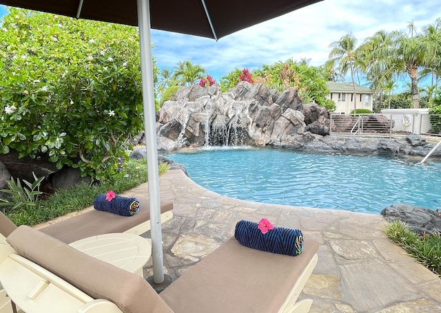 view of swimming pool featuring pool water feature and a patio