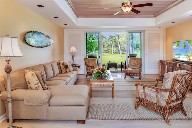 living room with ceiling fan, a tray ceiling, and wood ceiling