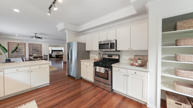 kitchen with white cabinets, appliances with stainless steel finishes, dark hardwood / wood-style flooring, ceiling fan, and crown molding