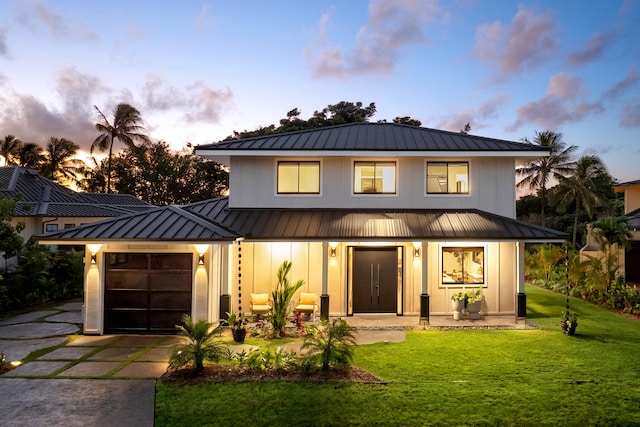 modern farmhouse featuring a lawn and a garage