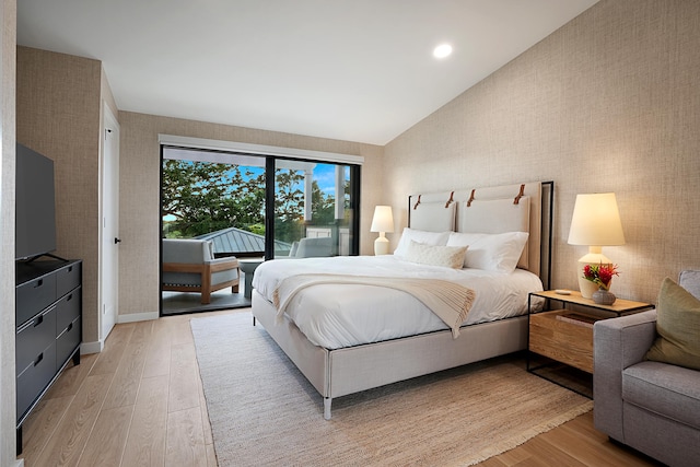 bedroom with access to outside, light hardwood / wood-style flooring, and lofted ceiling