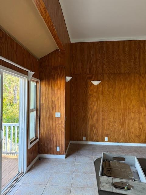 foyer featuring vaulted ceiling with beams, wood walls, and light tile patterned flooring