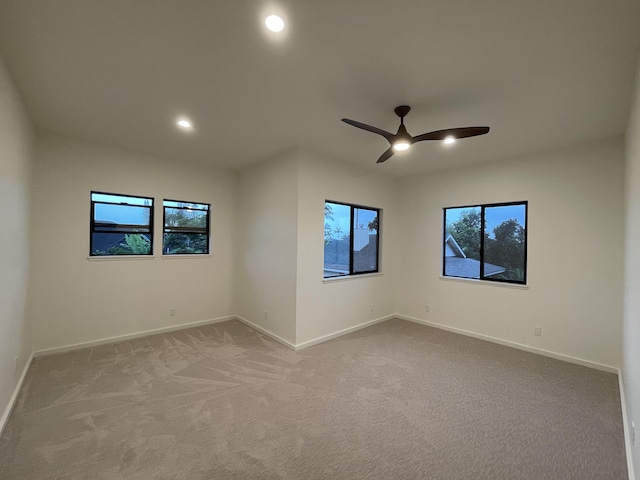 carpeted spare room with ceiling fan