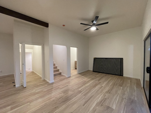 interior space featuring ceiling fan, light hardwood / wood-style flooring, and a towering ceiling