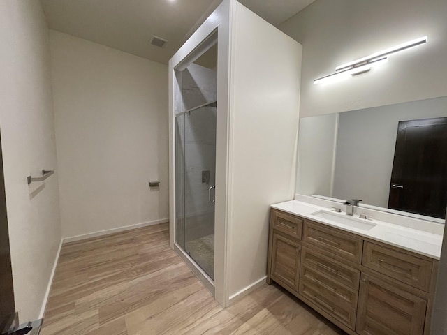 bathroom featuring vanity, an enclosed shower, and hardwood / wood-style flooring