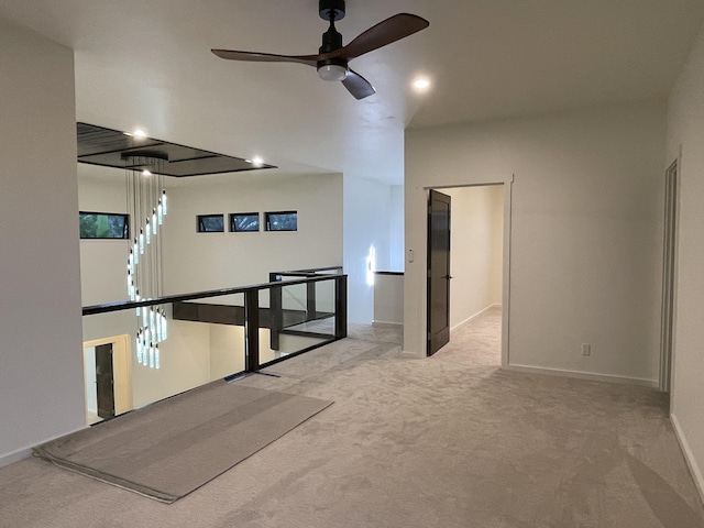 spare room with ceiling fan and light carpet