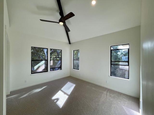 carpeted empty room featuring lofted ceiling with beams, ceiling fan, and a healthy amount of sunlight