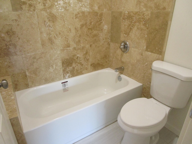 bathroom featuring bathtub / shower combination and toilet