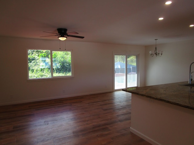 interior space featuring sink, dark wood-type flooring, and ceiling fan with notable chandelier