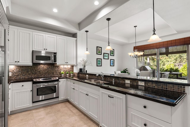 kitchen featuring a raised ceiling, sink, white cabinets, and appliances with stainless steel finishes