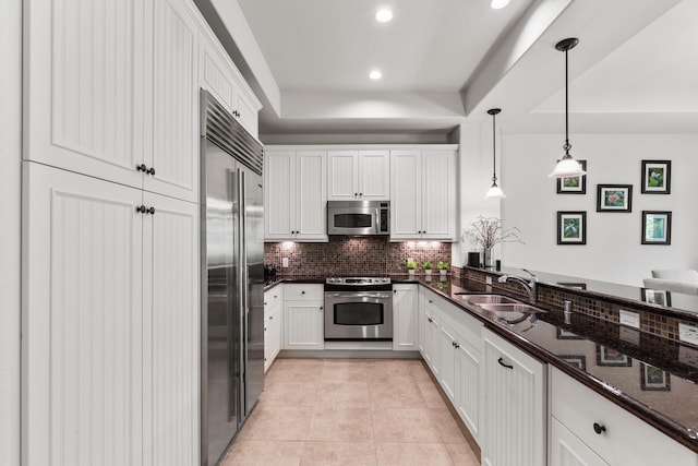 kitchen with pendant lighting, white cabinets, sink, light tile patterned floors, and stainless steel appliances