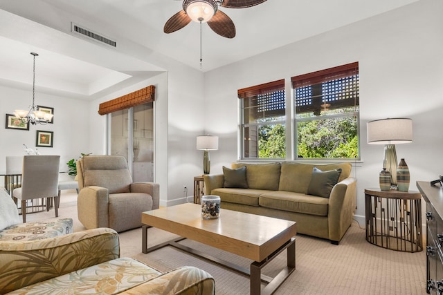 living room with ceiling fan with notable chandelier