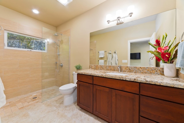 bathroom featuring vanity, toilet, and tiled shower