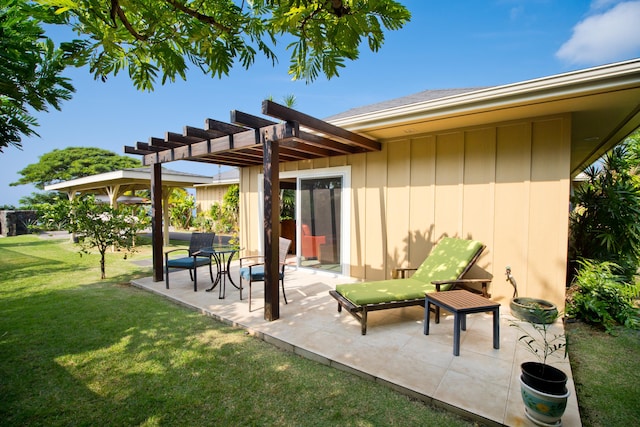 rear view of property with a yard, a pergola, and a patio area