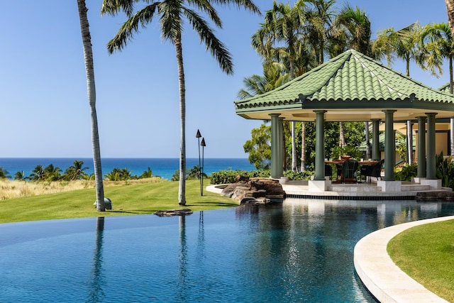 view of swimming pool featuring a gazebo, a water view, and a yard