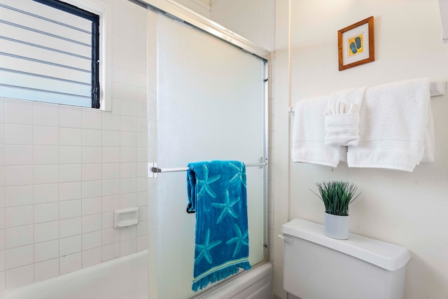 bathroom with bath / shower combo with glass door and toilet