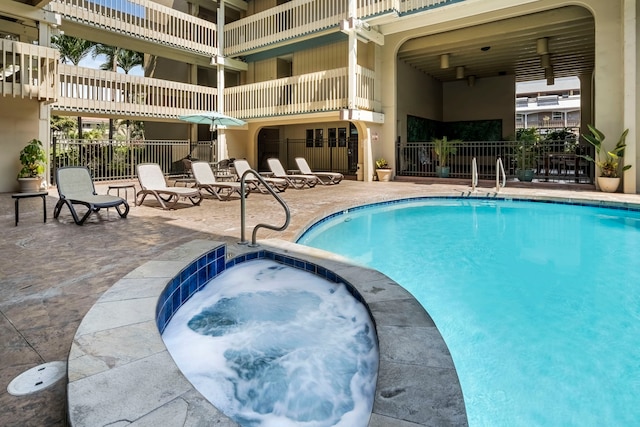 view of swimming pool with a hot tub