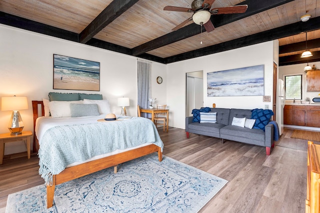 bedroom featuring ceiling fan, beamed ceiling, white fridge, wood ceiling, and hardwood / wood-style flooring