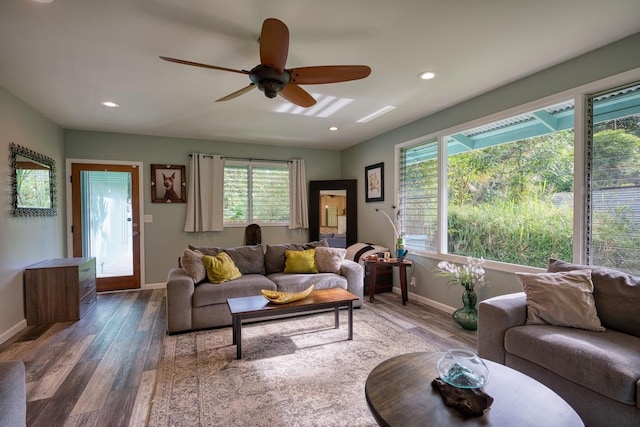 living room featuring dark hardwood / wood-style flooring, ceiling fan, and a healthy amount of sunlight