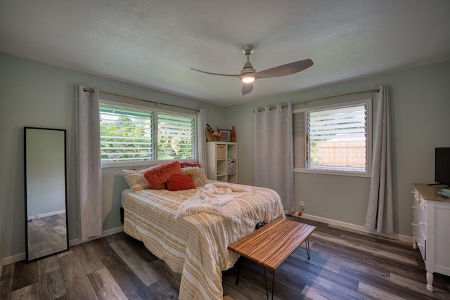 bedroom with multiple windows, ceiling fan, and dark hardwood / wood-style floors