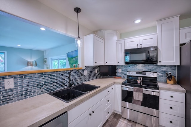 kitchen with tasteful backsplash, stainless steel appliances, sink, white cabinets, and hanging light fixtures