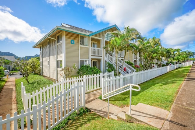 view of front of property with a mountain view and a front yard